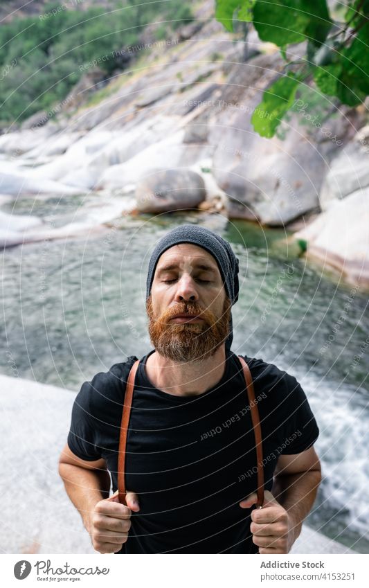 Ruhig reisender Mann in der Nähe des Flusses in den Bergen sorgenfrei Freiheit Hipster Tourismus Windstille Harmonie Natur männlich Reisender Felsen reißend