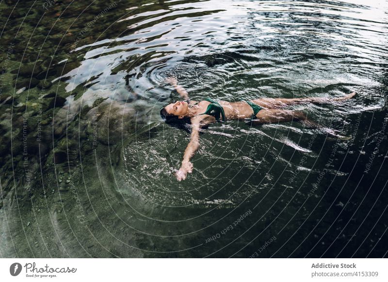 Serene Frau schwimmend auf See Wasser Schwimmer genießen Urlaub Gelassenheit sich[Akk] entspannen Teich Bikini Sommer Lügen Augen geschlossen Badebekleidung