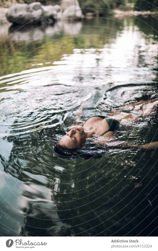 Serene Frau schwimmend auf See Wasser Schwimmer genießen Urlaub Gelassenheit sich[Akk] entspannen Teich Bikini Sommer Lügen Augen geschlossen Badebekleidung
