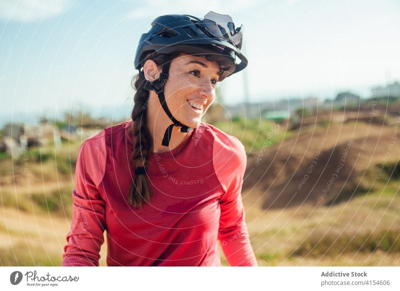 Radfahrerin mit Helm beim Üben auf der Trainingsstrecke Bahn Berge u. Gebirge Fahrrad praktizieren Frau Schutzhelm Testversion Trick Sportlerin Sportbekleidung