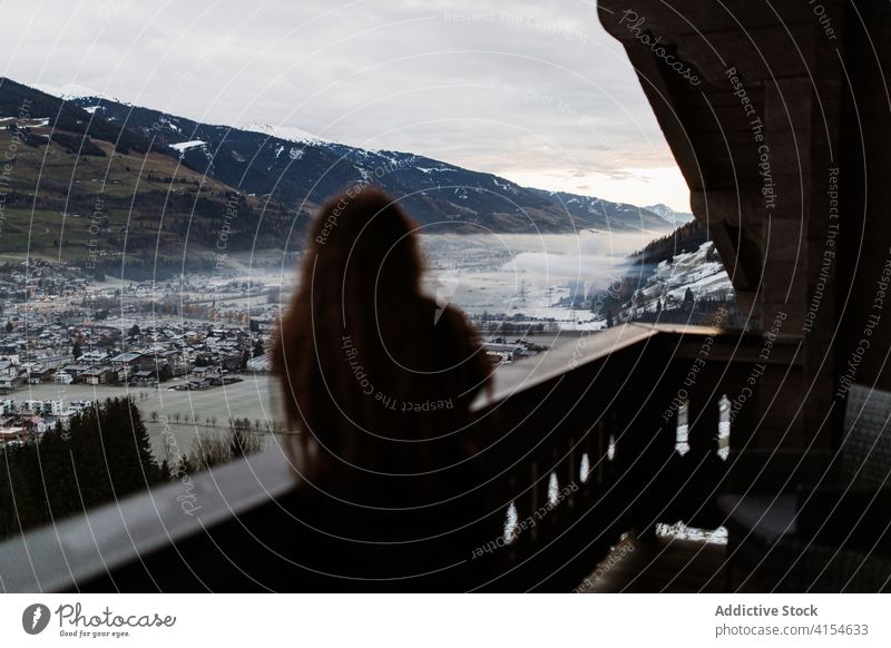 Frau auf einer Terrasse, die die Landschaft der Berge bewundert reisen Berge u. Gebirge Hotel genießen Stadtbild Tal Wohnsiedlung Winter Deutschland Österreich