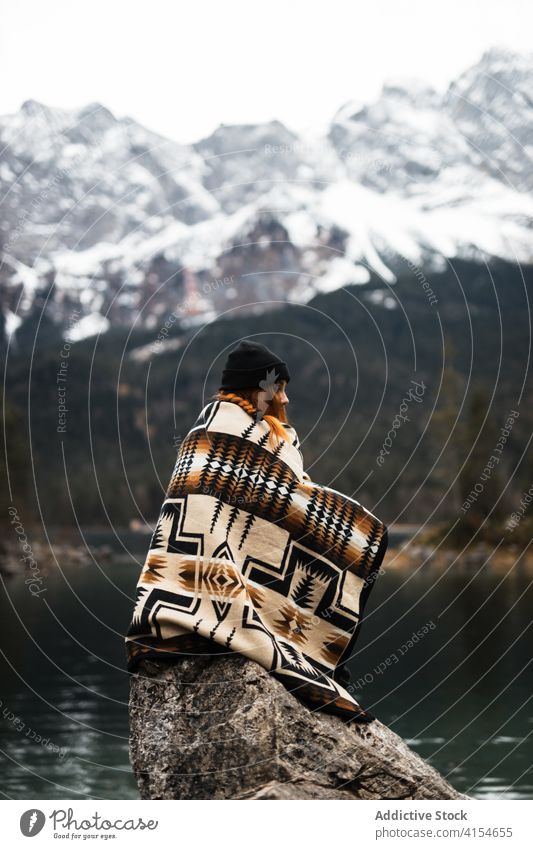 Frau ruht auf einem Stein in der Nähe eines Sees Berge u. Gebirge Felsen sich[Akk] entspannen einsam Winter Saison Hochland Urlaub Deutschland Österreich Teich