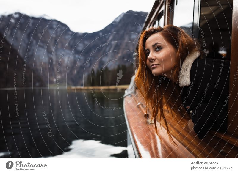Frau schaut aus dem Fenster während einer Bootsfahrt auf dem See reisen Berge u. Gebirge Herbst beobachten Natur Ausflug Reise Abenteuer Schiff Verkehr jung