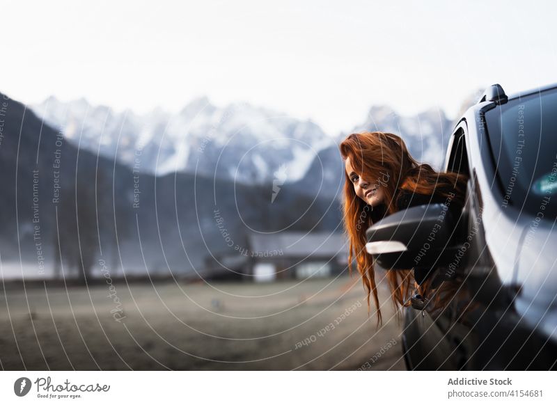 Frau schaut während einer Autofahrt in bergigem Gelände aus dem Fenster reisen PKW Berge u. Gebirge Herbst beobachten Natur Ausflug Reise Abenteuer Autoreise