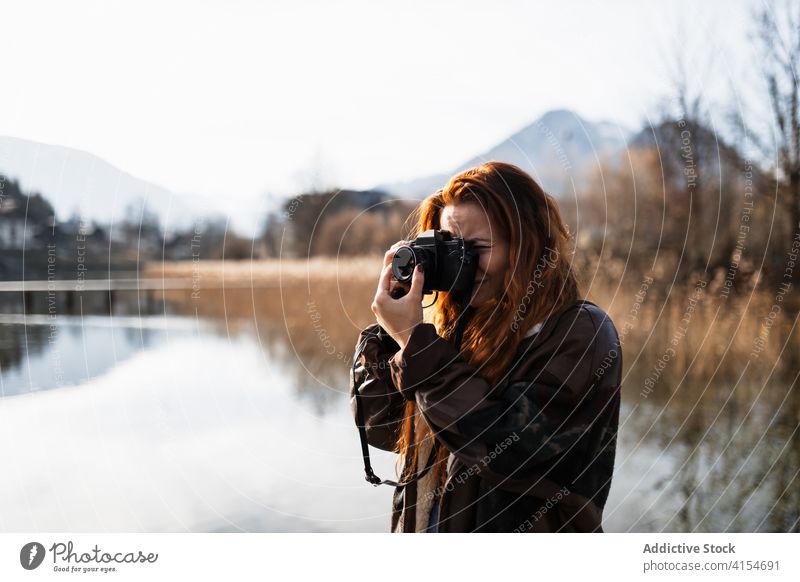 Fotograf nimmt Fotos von der Natur in der Nähe von See Frau Fotoapparat Herbst reisen fotografieren Ufer Schuss Berge u. Gebirge Reise Abenteuer jung Fotografie