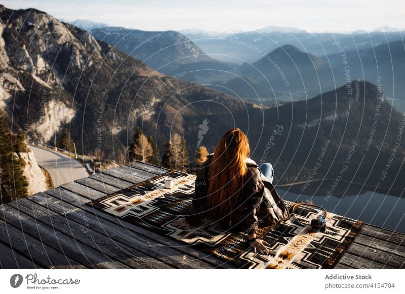 Reisende Frau auf Holzterrasse im Hochland Aussichtspunkt Berge u. Gebirge Morgen Reisender Nebel Sonnenstrahlen ruhig genießen Deutschland Österreich Tourist