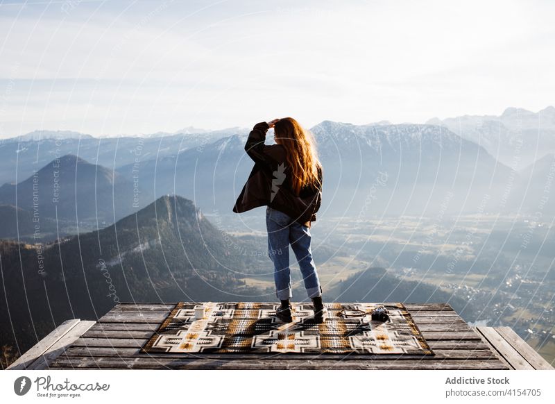 Reisende Frau auf Holzterrasse im Hochland Aussichtspunkt stehen Berge u. Gebirge Morgen Reisender Nebel Sonnenstrahlen ruhig genießen Deutschland Österreich