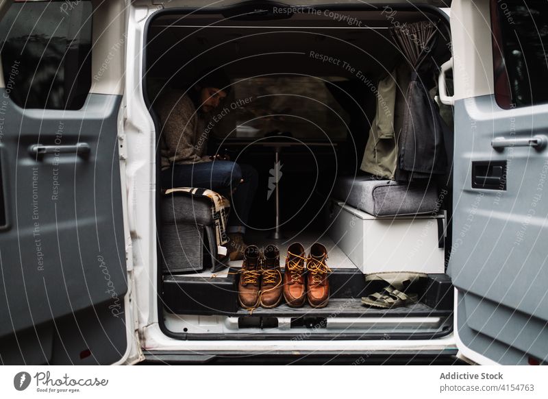 Mann entspannt sich im Lieferwagen während einer Fahrt im Herbst Kleintransporter reisen sich[Akk] entspannen Reise Verkehr Ausflug geparkt Reisender männlich