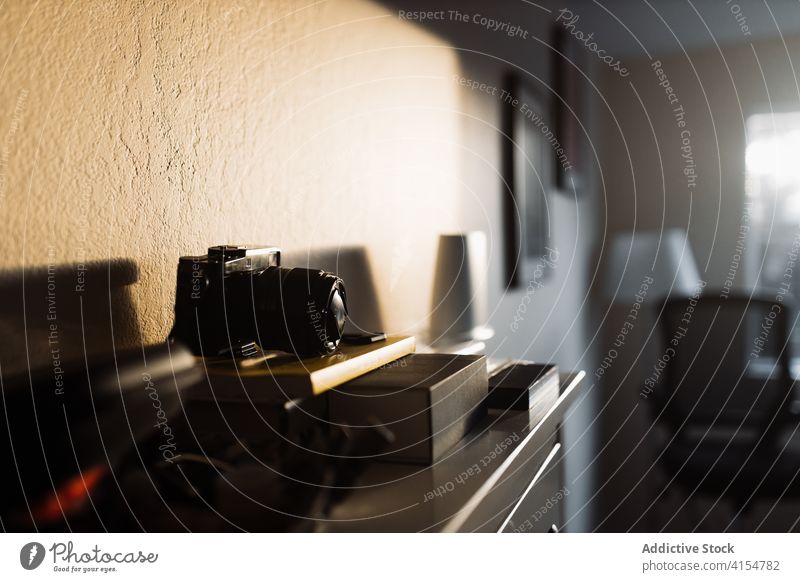 Moderne Kamera auf Kommode in Wohnung professionell Fotoapparat Fotografie Gerät Linse Fotokamera modern Appartement Sonnenlicht gemütlich Licht Objekt