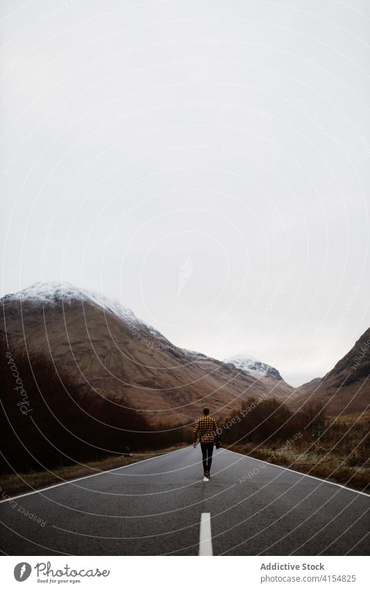 Unbekannter Mann auf Straße in den Bergen Berge u. Gebirge reisen leer wolkig trist Hochland Fahrbahn Reisender männlich Schottisches Hochland Schottland