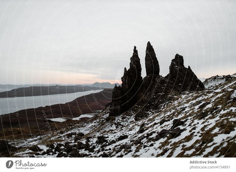 Raue Felsen am Meeresufer im Winter der alte Mann von Storr Ufer Schnee Berghang rau Formation Wahrzeichen berühmt Schottisches Hochland Schottland