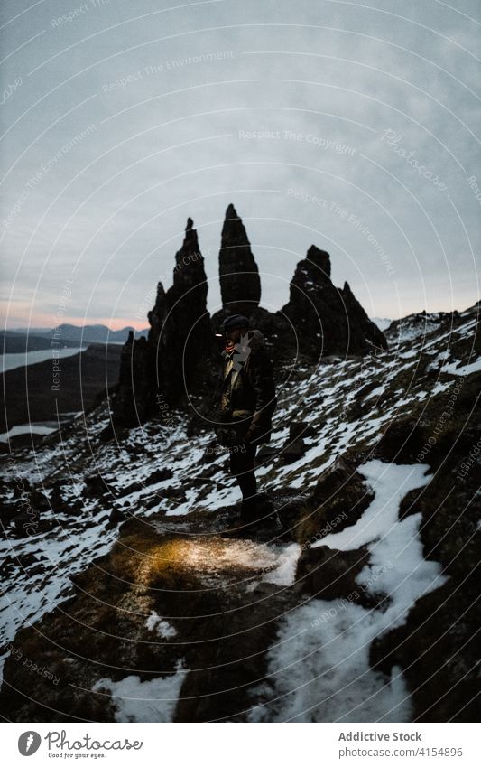 Reisender Mann in der Nähe von Old Man of Storr Winter der alte Mann von Storr Entdecker Saison kalt erkunden Felsen rau männlich Schottisches Hochland