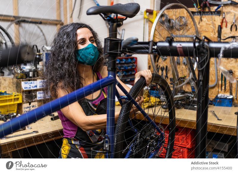 Frau repariert Fahrradrad in der Werkstatt Reparatur Mechaniker Rad Speiche fixieren Flugzeugwartung Beruf Dienst professionell Arbeit Job Wehen beschäftigt