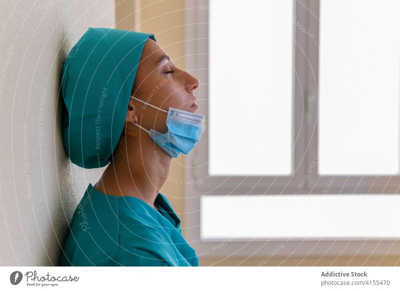 Überlastete Krankenschwester macht Pause im Krankenhausflur Sanitäter Krankenpfleger müde schwierig Überarbeitung überladen erschöpft Frau Coronavirus verärgert