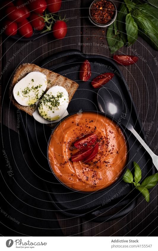 Appetitliche Tomatensuppe in einer Schüssel auf dem Tisch Suppe Schalen & Schüsseln lecker Abendessen Zuprosten Gemüse Garnierung Basilikum appetitlich Tablett