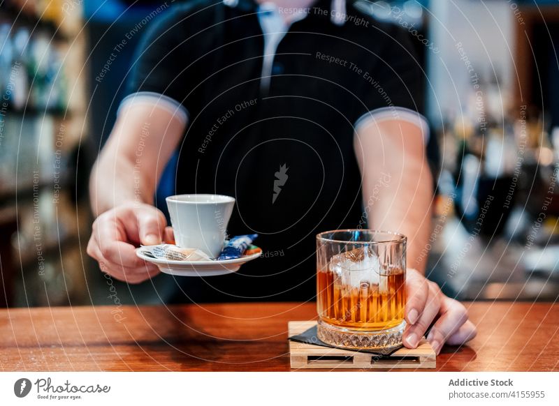 Crop Barkeeper serviert Getränke in einem Cafe dienen Barmann Abfertigungsschalter Kaffee Whiskey Alkohol frisch Dienst männlich Glas kalt Tasse Pub Erfrischung
