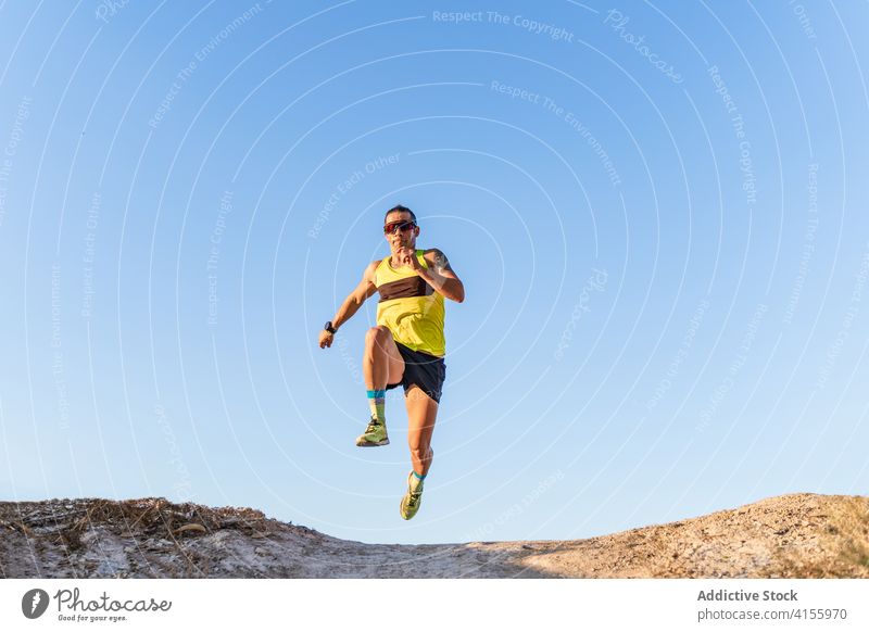 Starker Sportler springt und läuft gegen den blauen Himmel springen hoch Blauer Himmel Kraft Energie stark dynamisch aufgeregt erreichen Inspiration Athlet