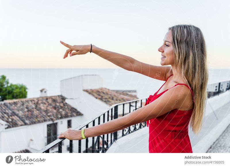 Zufriedene Frau auf Balkon in der Altstadt Tourist Terrasse Stadtbild bewundern beobachten Sommer genießen Lächeln Reling erstaunlich fettarm ruhen Großstadt
