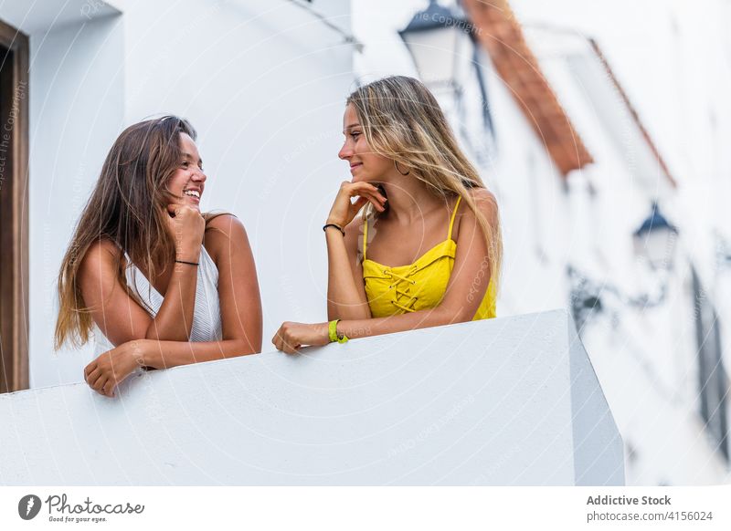Glückliche Frauen stehen auf der Terrasse eines Gebäudes in der Stadt Großstadt Freundschaft genießen Sommer Urlaub sich[Akk] entspannen positiv schlendern