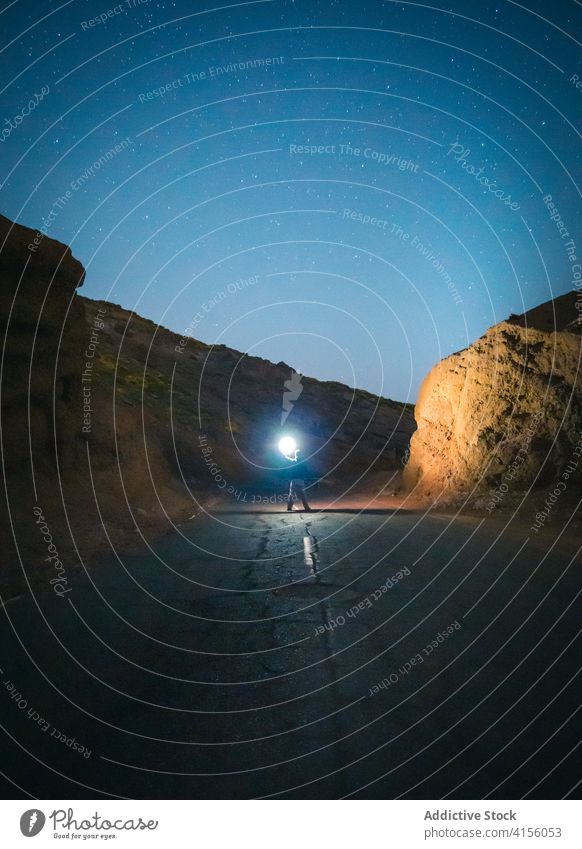 Unbekannter Reisender auf der Straße mit Taschenlampe leer reisen sternenklar Himmel Nacht leuchten Fackel Licht Stern Berge u. Gebirge Tourist Landschaft Natur