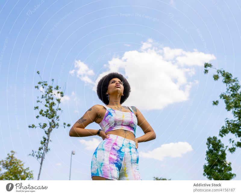 Selbstbewusste Sportlerin auf einer Wiese in der Stadt Großstadt Training Pause Frau Bestimmen Sie Sportbekleidung Sommer Rasen Athlet ethnisch schwarz