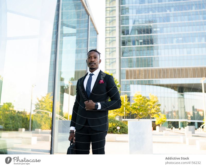 Stilvoller schwarzer Geschäftsmann auf der Straße Großstadt Zentrum Spaziergang Bestimmen Sie Unternehmer stilvoll Tracht Büro Gebäude männlich ethnisch