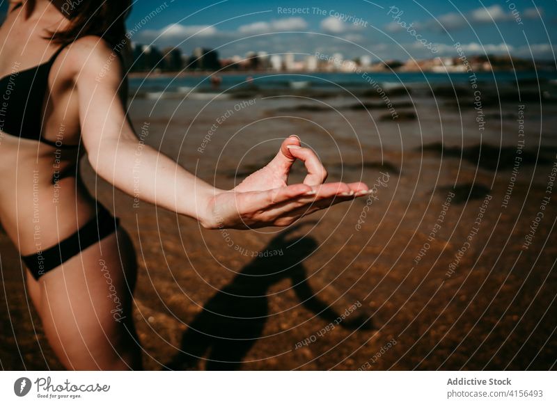 Crop Frau übt Yoga in Mountain Pose am Strand Berg-Pose Mudra gestikulieren üben urdhva hastasana schlank Meeresufer Sommer Wellness Seeküste Natur meditieren
