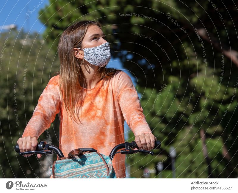 Junge Frau mit Maske fährt Fahrrad Mitfahrgelegenheit Straße Arbeitsweg Mundschutz Pandemie jung lässig Sommer Tasche Coronavirus COVID19 Bund 19 neue Normale