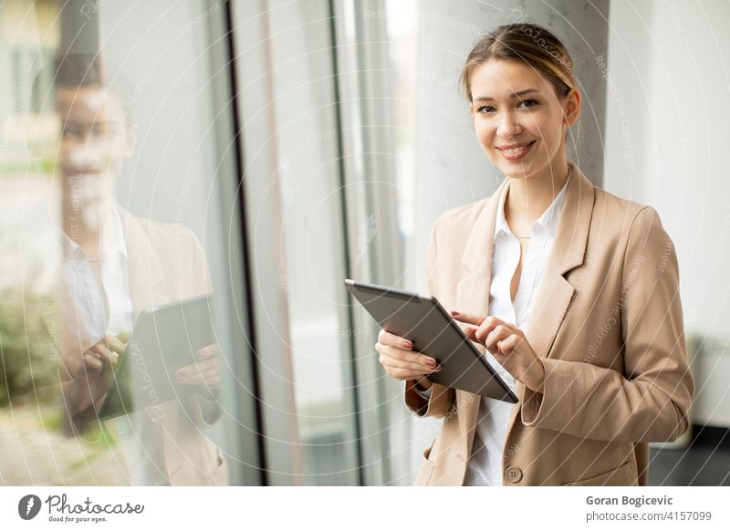 Junge Frau hält digitales Tablet in modernem Büro Erwachsener attraktiv schön Business Geschäftsfrauen Anzeige elektronisch Glück Beteiligung im Innenbereich