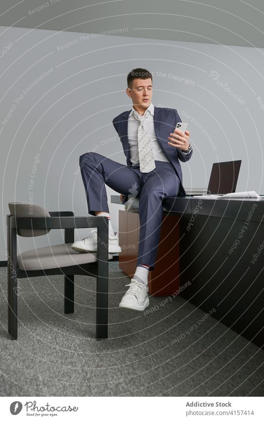 Stilvoller Geschäftsmann am Handy im Büro Smartphone Business sitzen Tisch benutzend Unternehmer männlich Arbeitsplatz Stuhl Beruf Gerät Apparatur beschäftigt
