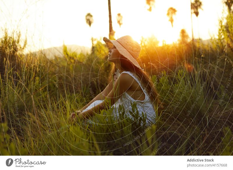 Charmante Frau auf einem Feld im Sommer Sonnenhut Wiese Sonnenuntergang Abend Angebot sorgenfrei sich[Akk] entspannen Lächeln Natur genießen heiter romantisch