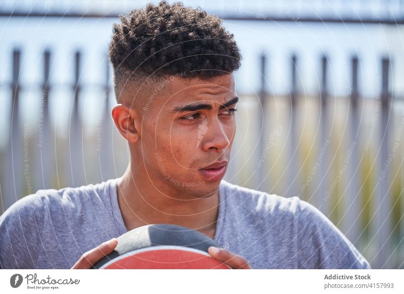 Selbstbewusster schwarzer Basketballspieler mit Ball Spieler selbstbewusst Mann Bestimmen Sie Sportpark Gericht Sommer Sportler männlich ethnisch Afroamerikaner
