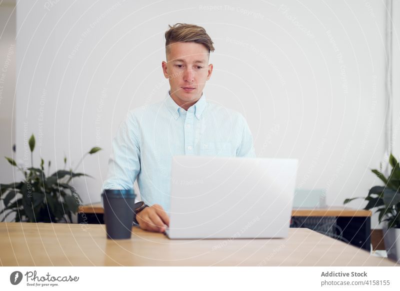 Konzentrierter Mann mit Laptop am Arbeitsplatz freiberuflich Unternehmer beschäftigt Inbetriebnahme Imbissbude Kaffee Arbeitsbereich männlich hölzern Tisch