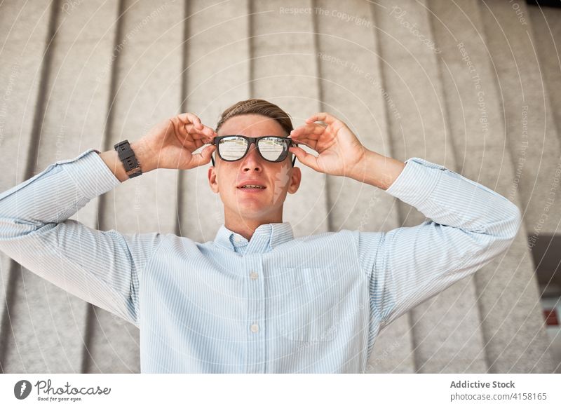 Selbstbewusster junger Mann mit modischer Sonnenbrille Stil trendy selbstbewusst Brille modern urban Mode Geschäftsmann Zeitgenosse Outfit männlich Unternehmer