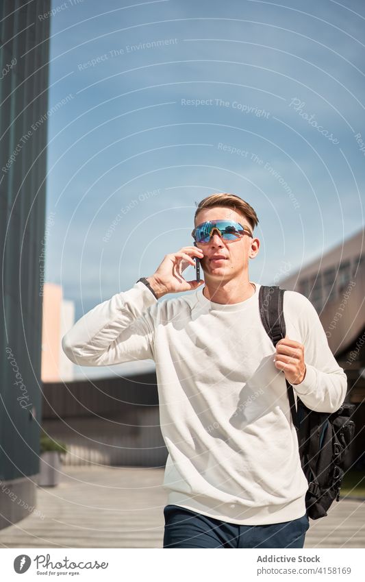 Moderner Mann mit modischer Sonnenbrille, der in der Stadt telefoniert Stil Smartphone reden urban modern selbstbewusst trendy Telefon jung männlich Mobile