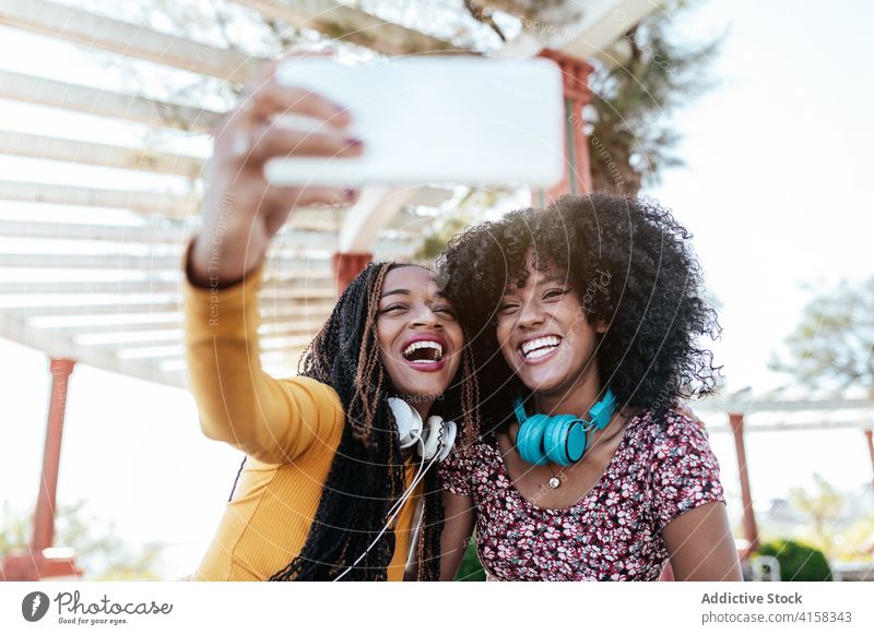 Fröhliche schwarze Freunde nehmen Selfie in der Stadt Umarmung Smartphone Frauen Freundschaft heiter Bonden benutzend Sommer Spazierweg ethnisch Afroamerikaner