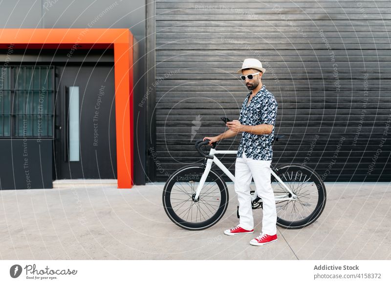 Mann mit Fahrrad auf der Straße und Smartphone trendy Großstadt Browsen Stil Fahrzeug männlich Mobile Telefon Surfen online Internet modern Gerät Hipster