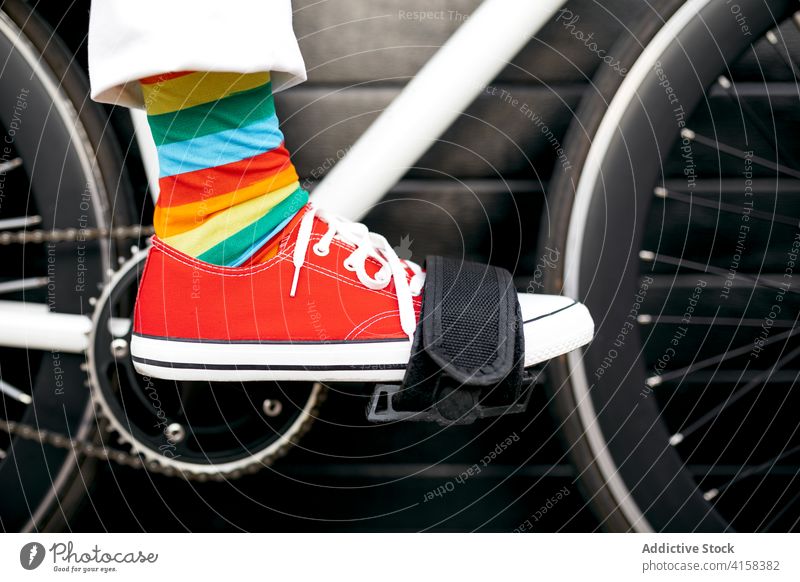 Crop Person in bunten Socken auf dem Fahrrad Streifen Kniestrümpfe farbenfroh Regenbogen kreativ Spaß Fahrzeug modern Großstadt Straße urban Stil trendy Verkehr