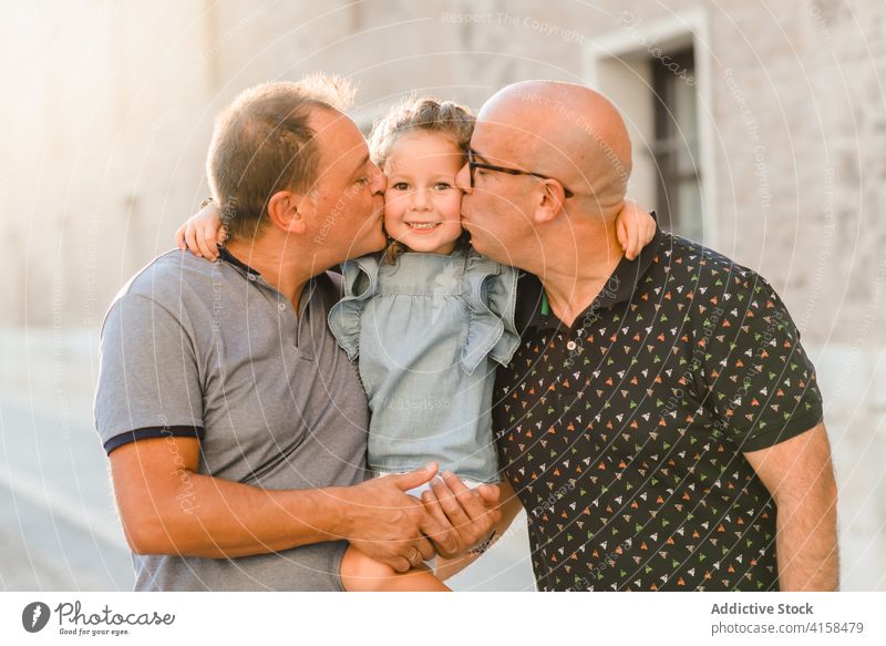 Erfreute LGBT-Familie auf der Straße lgbt Zusammensein Vater Männer schwul Paar Kind unterhalten Großstadt Durchgang Wochenende Sommer Spaziergang Glück Freude
