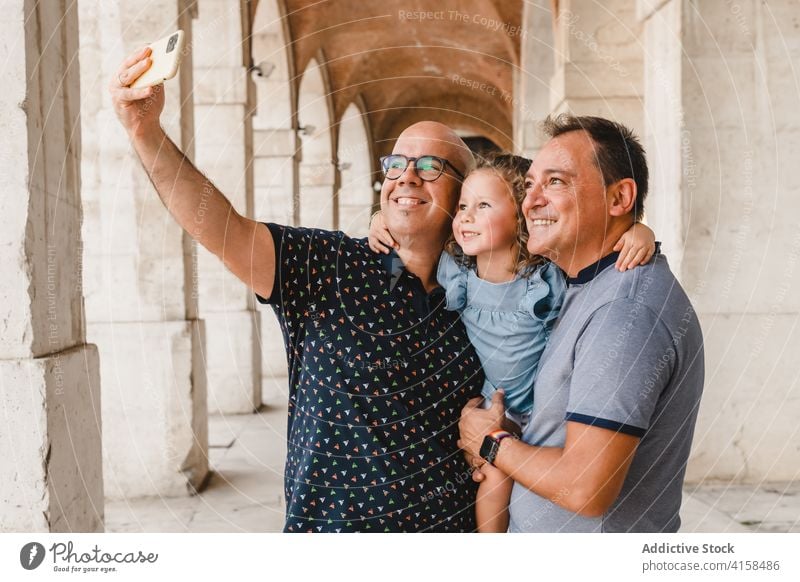 Fröhliche LGBT-Familie nimmt Selfie in der Stadt lgbt Kind Paar schwul Männer Mädchen Smartphone Homosexualität Zusammensein fotografieren Selbstportrait