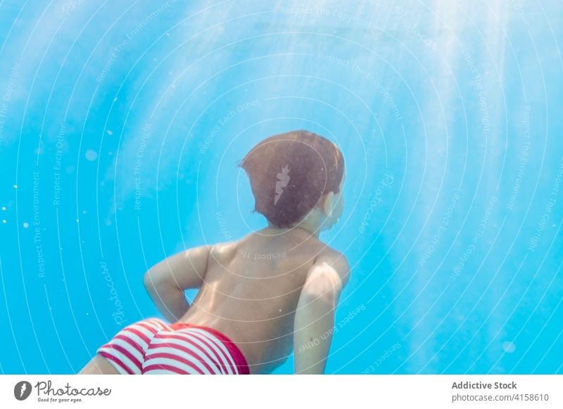 Anonymer Junge im Schwimmbad schwimmen Pool Kind Sinkflug spielerisch Freude Kindheit Urlaub Sommer Spaß haben Wasser aqua Badeanzug übersichtlich Feiertag