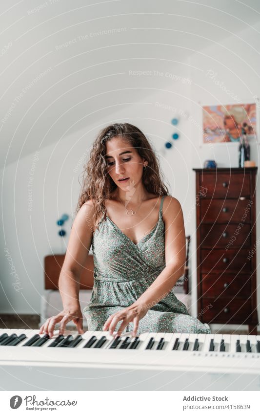 Frau spielt Klavier im Wohnzimmer spielen Musik Musiker Probe Talent Fähigkeit kreativ Melodie ethnisch modern Appartement Gesang ausführen Klang unterhalten