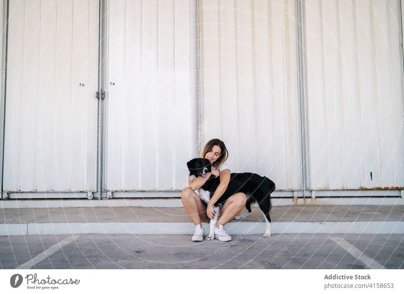 Frau mit Hund sitzt an der Wand Zusammensein Besitzer Haustier Eckzahn urban Begleiter sitzen jung Teenager tausendjährig Lifestyle Tier Freund heimisch