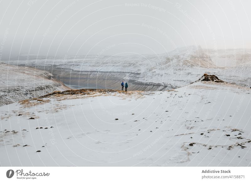 Anonyme Menschen, die die herrliche Aussicht auf die Berge betrachten Berge u. Gebirge Fluss Schnee Winter Landschaft wolkig Saison kalt Ambitus Färöer-Inseln