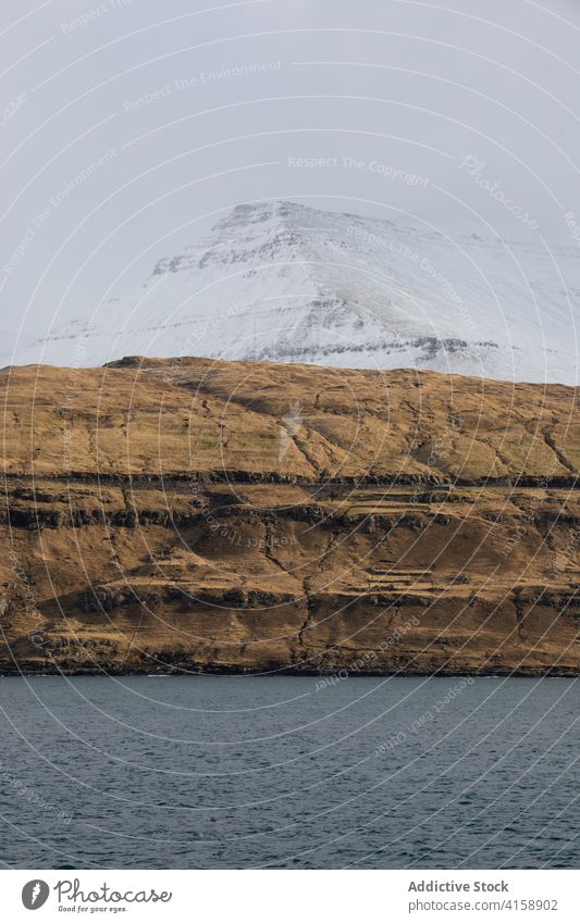 Felsenklippe in Meeresnähe auf den Färöer Inseln Klippe MEER Meereslandschaft Winter Schnee Saison kalt steil Gelände Färöer-Inseln felsig Landschaft