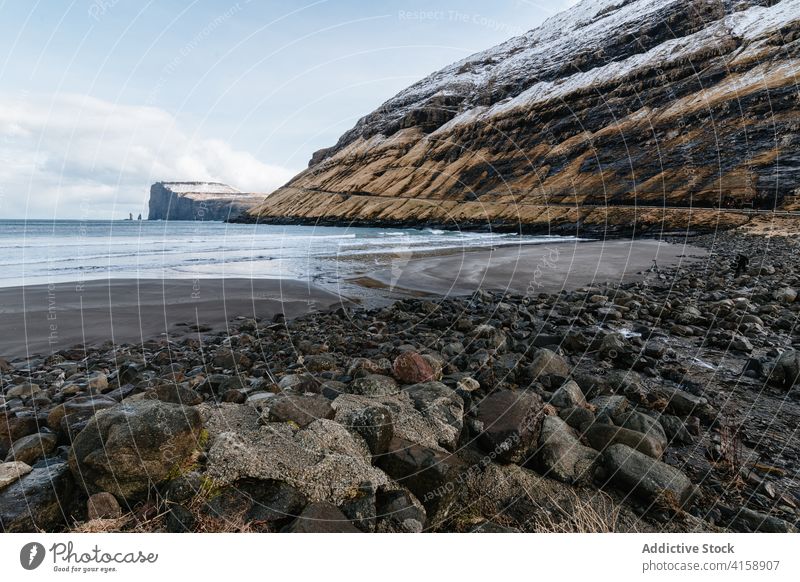 Felsenklippe in Meeresnähe auf den Färöer Inseln Klippe MEER Meereslandschaft Winter Schnee Saison kalt steil Gelände Färöer-Inseln felsig Landschaft