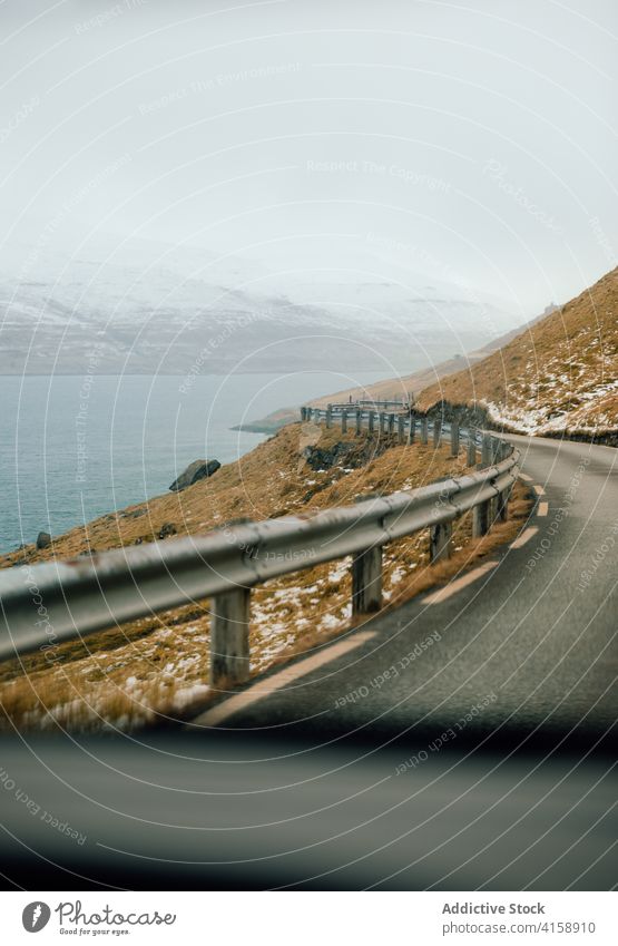 Asphaltierte Fahrbahn im Hochland der Färöer Inseln Berge u. Gebirge Straße Fluss Winter Schnee Regie Natur Landschaft Färöer-Inseln malerisch Wasser Frost