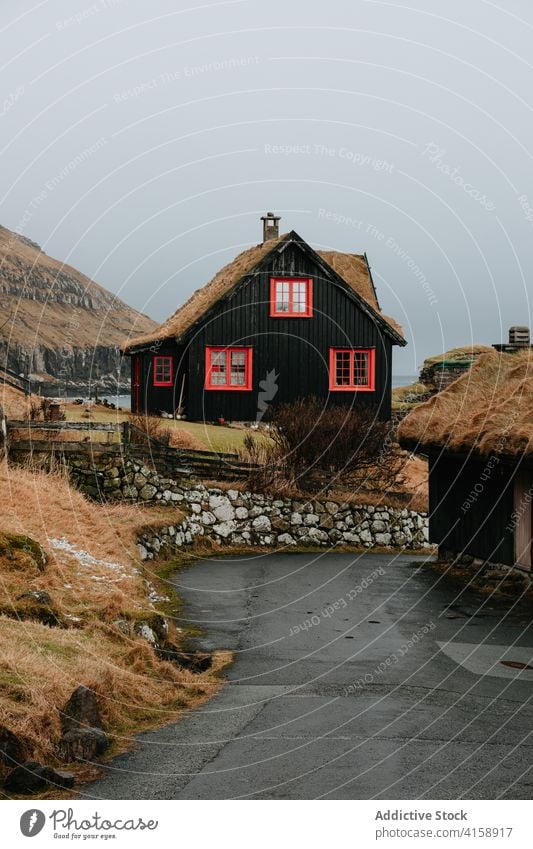 Holzhaus auf Färöer Inseln auf Berg Dorf Häuser Winter kalt Berge nordisch Färöer-Inseln reisen Küstenstreifen Urlaub berühmter Ort Tourismus