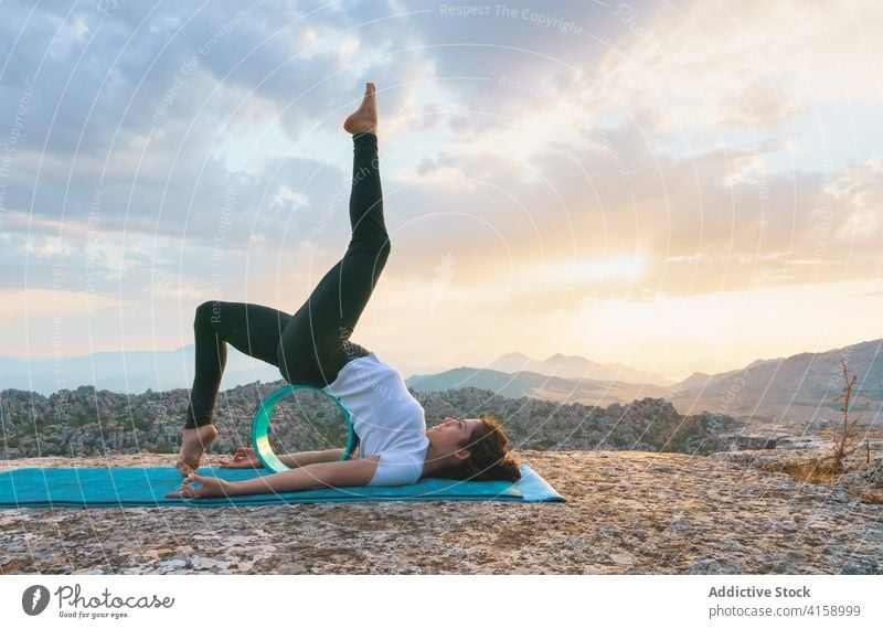 Flexible Frau beim Üben einer Asana mit Yogarad Rad Backend Brücke Variation Dehnung beweglich Gerät eka pada setu bandha sarvangasana Natur Pose