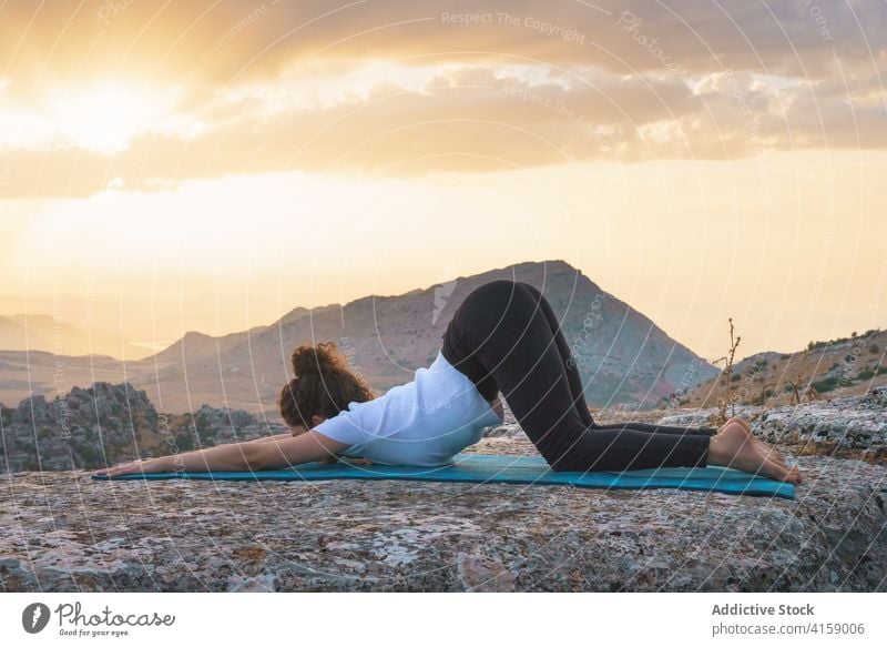 Frau streckt Körper in Yoga-Position in der Natur Asana verlängerter Welpe Pose uttana shishosana Berge u. Gebirge Dehnung beweglich üben positionieren Felsen